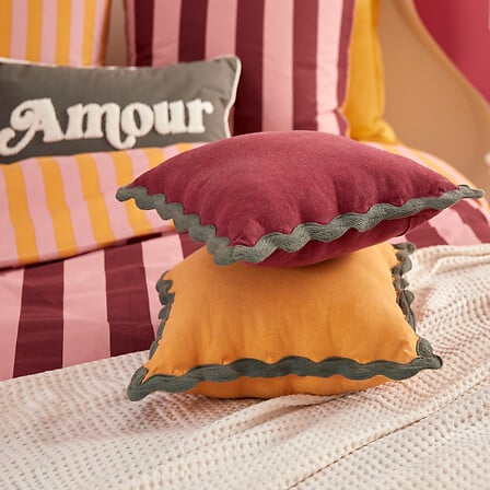 Coussin carré jaune ocre à bordure ondulée verte